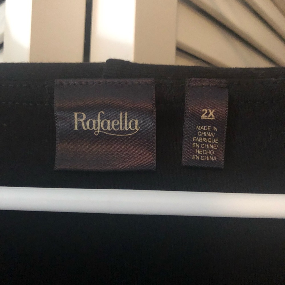 Black Rafaela sweater with jeweled neck pin.